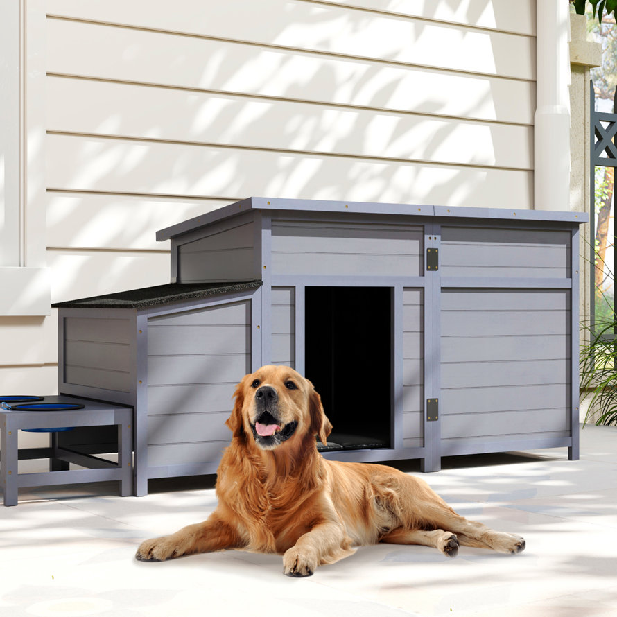 Golden retriever in a gray doghouse on a lawn.
