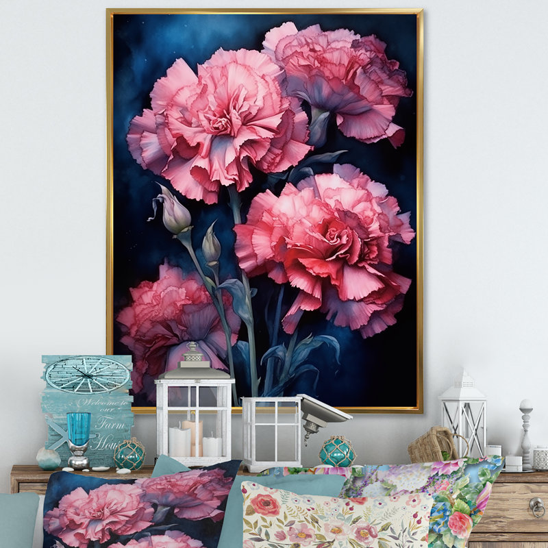 Framed wall art featuring pink carnations on a navy blue background hanging above a console table with decorative lanterns and pillows.