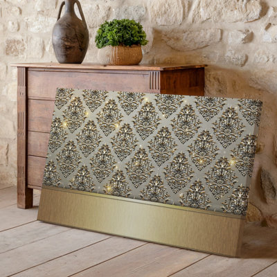 La toile crée un design de papier peint élégant avec un motif damassé complexe en or chatoyant contre un taupe doux