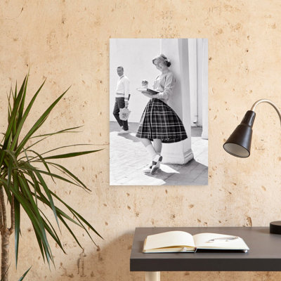 1950S, 1960S, Adolescente, adossée à une colonne, mangeant un livre de lecture, regardant un appareil photo souriant comme un petit ami potentiel qui se promène ...