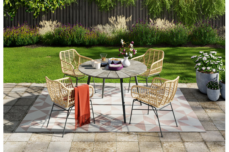 modern patio dining set with a geometric-patterned outdoor rug