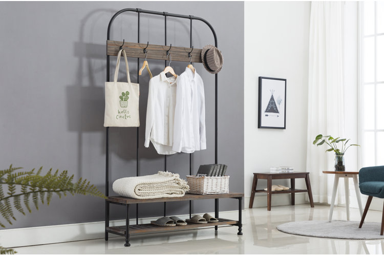 metal hall tree with coat hooks and shoe storage in a studio apartment entryway