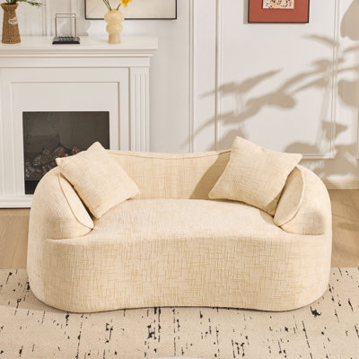 Canapé compressible beige pour deux personnes. Il a des accoudoirs des deux côtés, est livré avec deux coussins, convient aux petits appartements et peut être placé dans le salon ou la chambre à coucher.