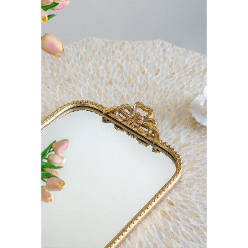 Plateau de service orné en fer doré avec surface réfléchissante réfléchissante, décoration élégante et fonctionnelle.