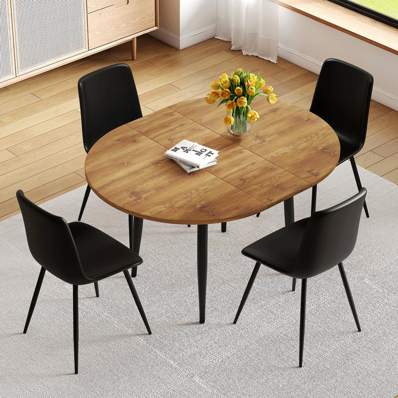 Ensemble de table et de chaises. Table de salle à manger moderne en MDF extensible. Convient pour des rassemblements de différentes tailles. Assorti de 4 chaises en polyuréthane artificielles noires avec coussins incurvés.