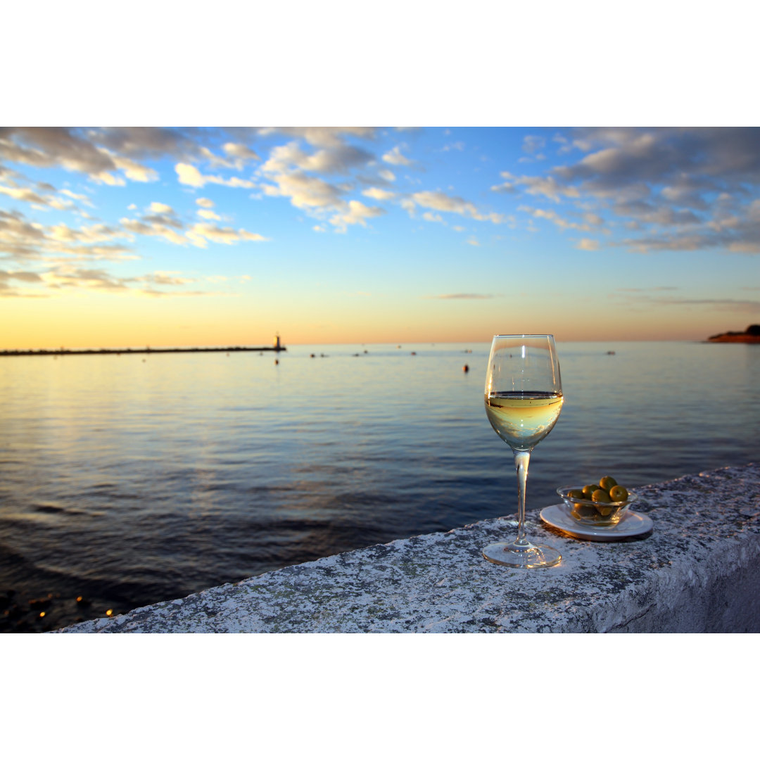 Ein Glas Wein und Oliven am Meer