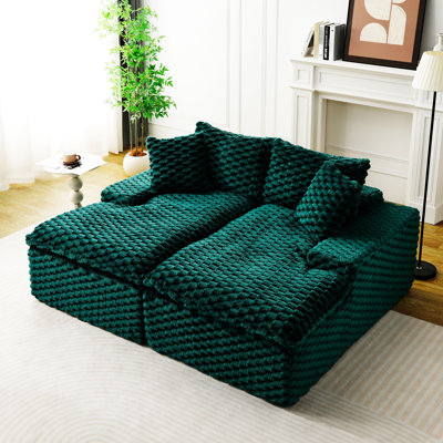 Chaise longue double recouverte de velours tortue, garnie de mousse comprimée, confortable pour 2 personnes dans un coin salon.