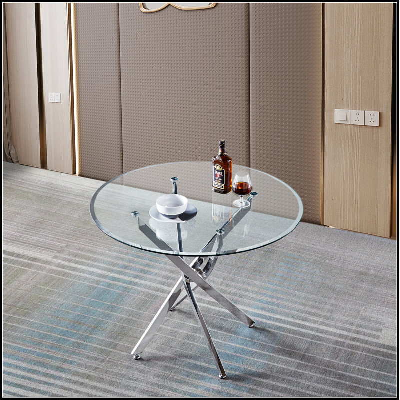 Table de salle à manger ronde contemporaine en verre trempé transparent avec pieds élégants en acier inoxydable à finition argentée, parfaite pour les intérieurs modernes et les espaces compacts.