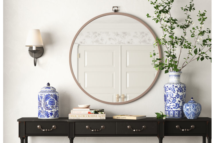traditional-style entryway with a circular wall mirror and chinoiserie vases