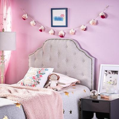 Tête de lit tapissier simple grise avec capitonnage moderne et détails cloutés
