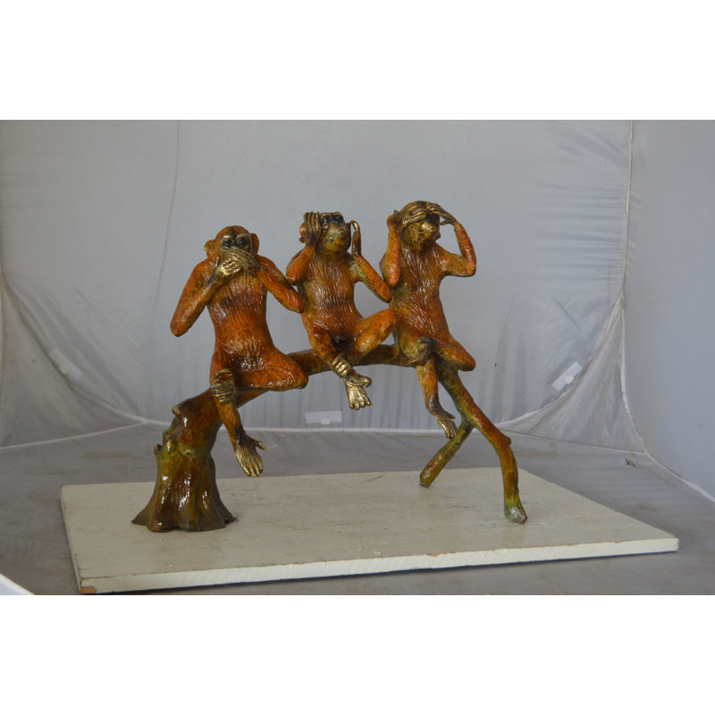 Statue de trois singes sages sur une branche d'arbre