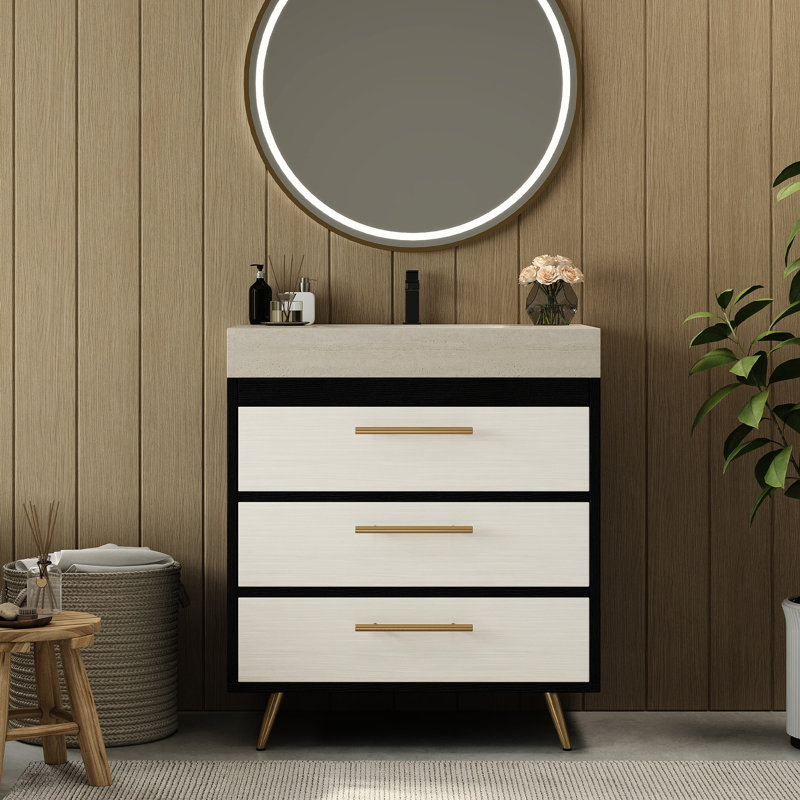 Meuble-lavabo sur pied contemporain avec lavabo en céramique intégré et surface en pierre frittée. Ce meuble-lavabo offre un support stable avec ses pieds en acier thermolaqué et ses poignées encastrées dorées. L'évier a un grand