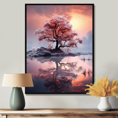 Arbre rose unique au coucher du soleil sur le lac