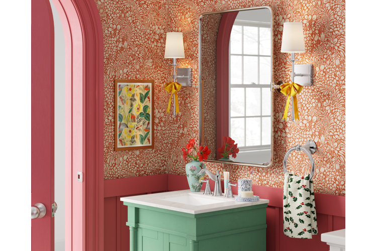 Bathroom with red and orange floral wallpaper, a green bathroom vanity, and a rectangular vanity mirror.