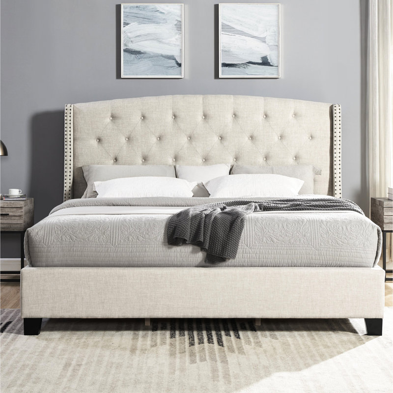 Grand lit beige avec capitonnage à boutons et garniture de tête de lit