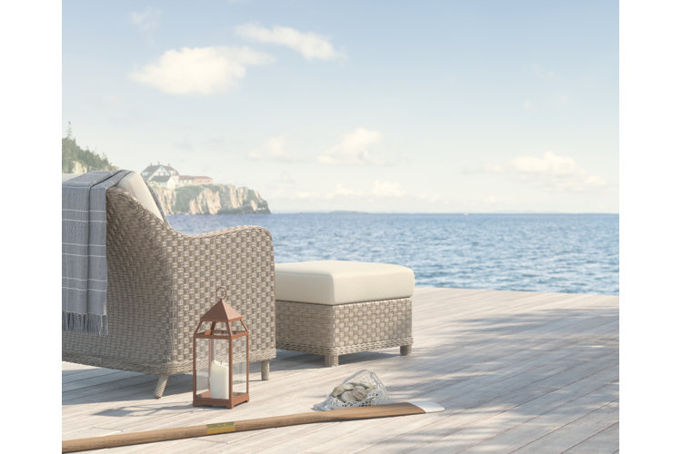 beach house deck with a wicker outdoor chair and a view of the ocean
