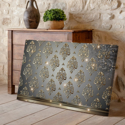 La toile crée un design de papier peint élégant avec un motif damassé complexe en or chatoyant contre un taupe doux