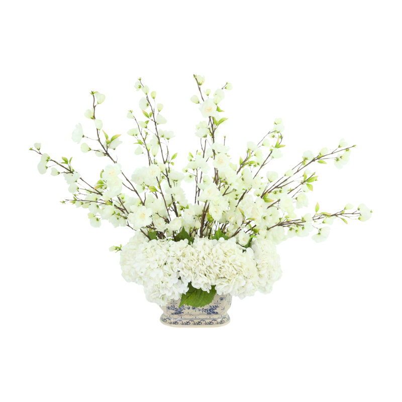Arrangement de fleurs de cerisier et d'hortensias dans un vase en céramique