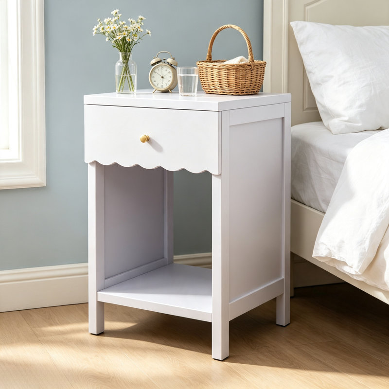 Table de chevet en forme de pétoncle, lilas pâle, avec un tiroir et une étagère ouverte, ornée de boutons dorés, dans la chambre.
