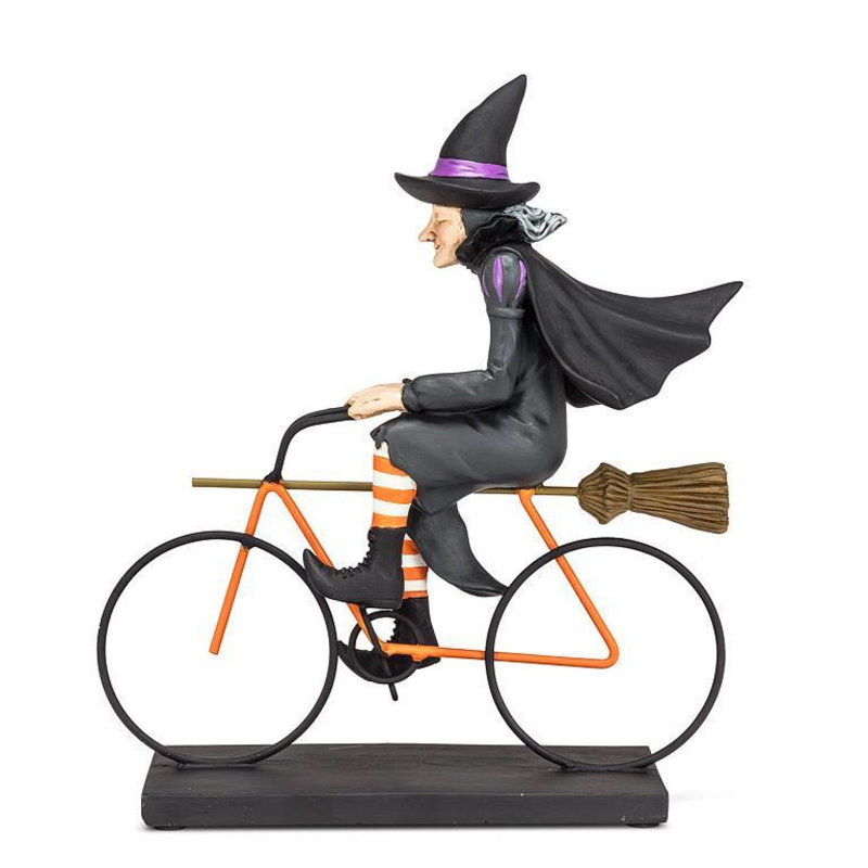 Figurine de sorcière chevauchant un vélo
