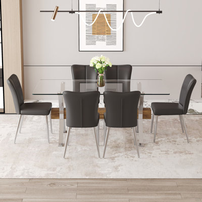 Ensemble de table et de chaises. Ensemble de salle à manger élégant en verre trempé transparent - 71 po x 35,4 po avec chaises en polyuréthane avec un motif à rayures verticales sur le dossier. Traverses en bois aggloméré, pieds en métal argenté.