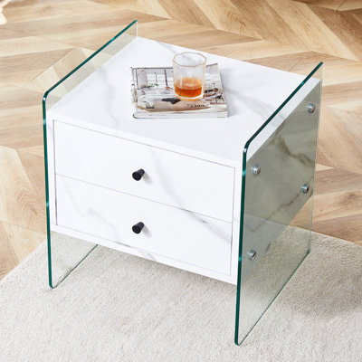 Double-drawer bedside table. The board surface is MDF with white grain sticker, and both sides are transparent tempered glass. The design is simple and elegant, with excellent storage functions.
