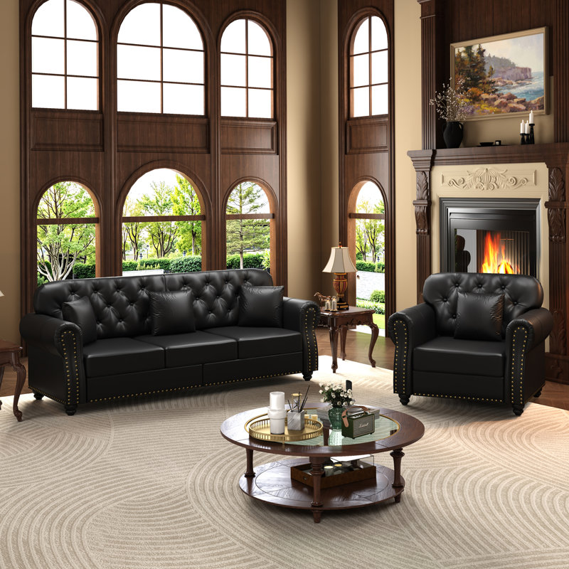 Canapé Chesterfield rembourré en similicuir avec capitonnage à boutons, garniture cloutée, accoudoirs roulés et coussins inclus pour un confort intemporel et une élégance moderne.