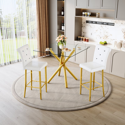 Table de bar moderne et tabourets à hauteur fixe, piètement en verre doré en forme de X avec assises en similicuir blanc, pour petits bars à domicile, salles à manger, construction stable, dossiers ergonomiques, entretien facile.