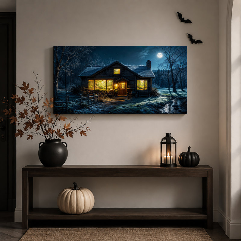 Cabane en bois rond enneigée aux fenêtres illuminées sous une toile murale d'Halloween, L 46 po x H 24 po