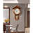 Vintage solid wood wall clock with a roof-shaped top and a metal pendulum