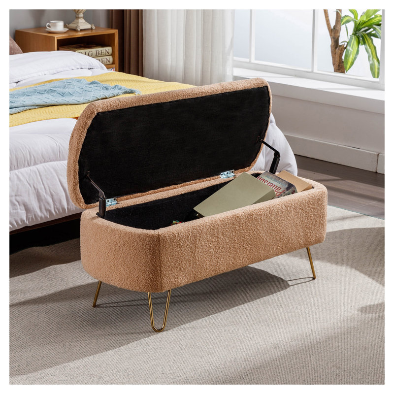 Pouf de rangement en fausse fourrure camel avec pattes dorées, idéal pour une chambre, au pied du lit ou dans une entrée.