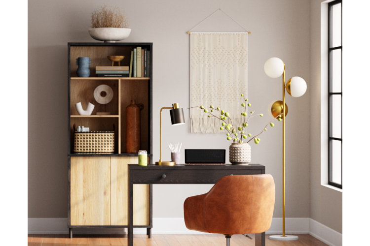 Home office with a beige macrame wall hanging, boho accent cabinet, and orange leather chair.