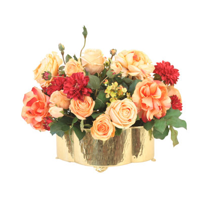 Fleurs mélangées aux tons crépusculaires dans un pot en laiton
