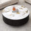 Table basse ronde en pierre frittée et MDF, plateau en faux marbre monobloc, piètement en placage noir, 2 tiroirs et pieds en acier.