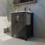 Une armoire de salle de bain noire de 24 pouces, jumelée à un lavabo en céramique blanche, présente un design moderne et est faite de matériaux imperméables et durables.