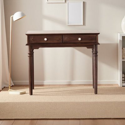 A wooden antique desk with copper handles