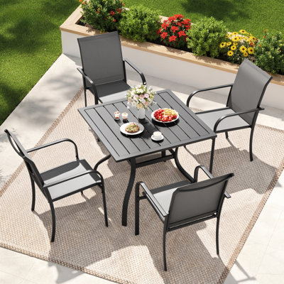 Ensemble de salle à manger de patio pour 4 personnes avec table de salle à manger carrée en métal Behrendt et chaises empilables en polyester enduit de PVC