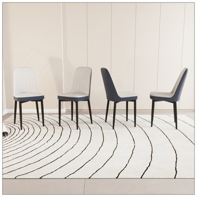 Un ensemble de 4 chaises de salle à manger, de style moderne, fabriquées en similicuir de haute qualité avec des coussins moelleux épais, des pieds de cuisine en métal noir et des chaises de salle à manger