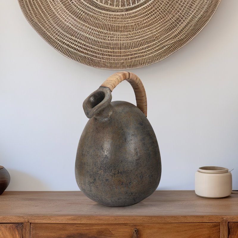 Decorative Terracotta Vase with Sculpted Form, Tilted Mouth, Matte Pottery Texture, and Woven Rattan Wrapped Handle for Textural Contrast and Handcrafted Visual Interest in Casual Home Accents