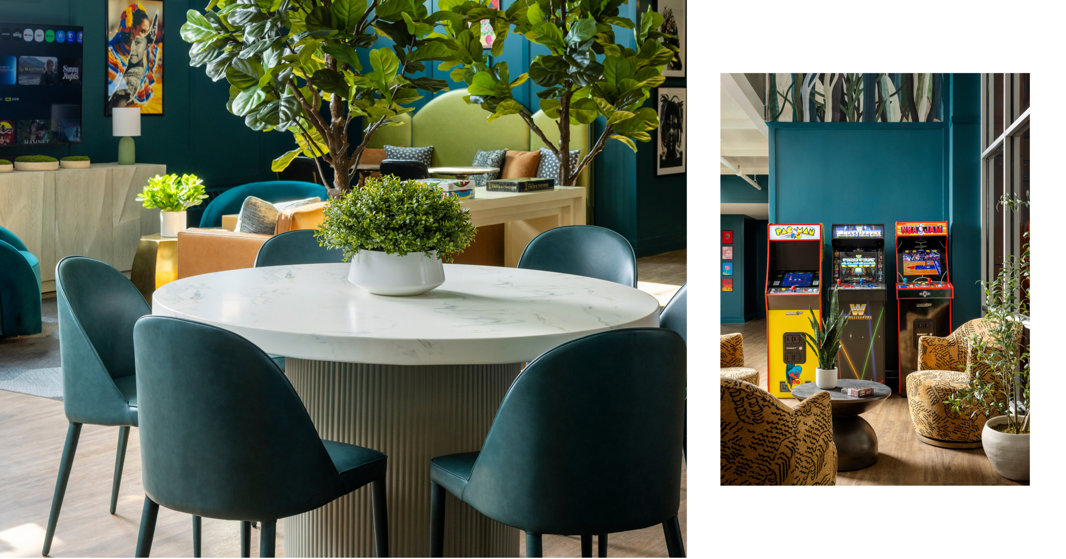 Interior space with blue chairs around a round table and arcade game machines in the background.