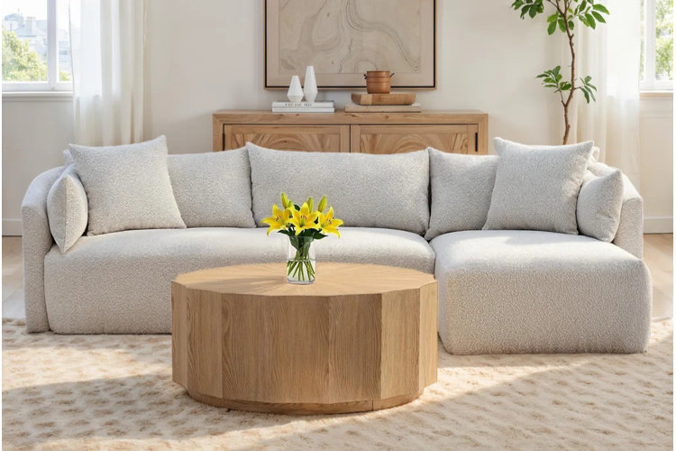 rubberwood drum coffee table with a gray sectional sofa in an organic modern living room