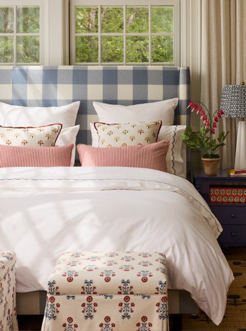 Bedroom with blue and white gingham headboard.