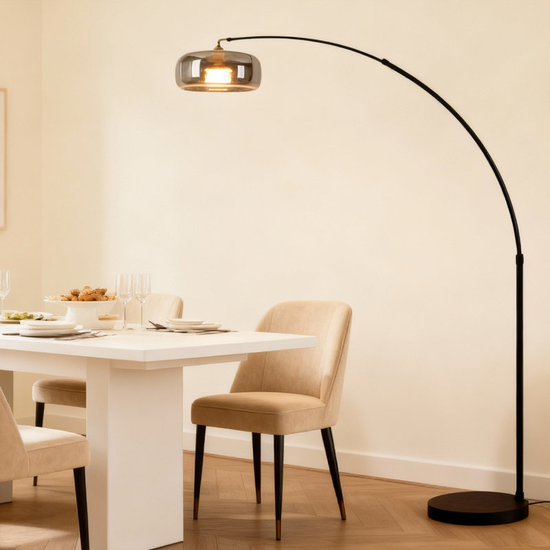 La lampe sur pied avec abat-jour en verre ambré avec un mât arqué au design moderne et minimaliste ajoute une atmosphère chaleureuse à l'espace.