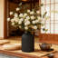 Vase en métal noir mat avec fausses mamans blanches et centre de table en eucalyptus
