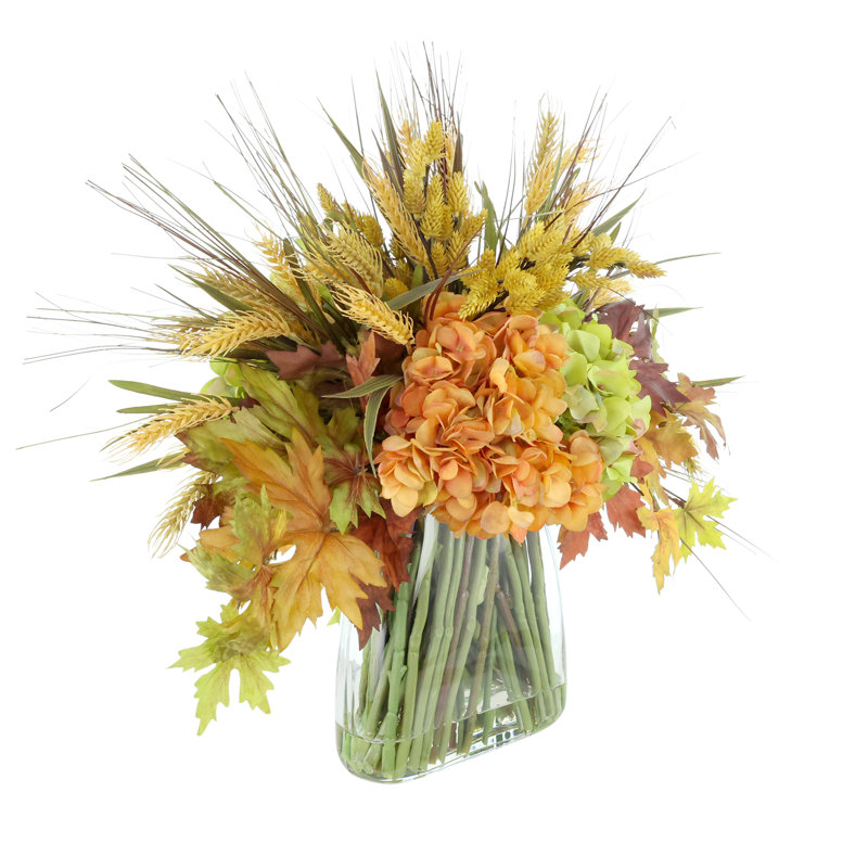 Arrangement d'hortensias d'automne et de blé dans un vase en verre