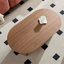 Table basse ovale en panneau de fibres à densité moyenne brun avec base piédestal, design compact et moderne pour le salon