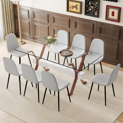 Ensemble de table et de chaises. Table de salle à manger élégante en verre trempé transparent - 71 po x 35,4 po avec chaises en tissu de lin. Grande table avec pieds en métal de couleur noyer en forme de X et barres transversales en panneau de fibres à densité moyenne.