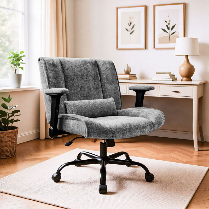 Grey upholstered office chair with a lumbar pillow, black armrests, and a five-wheel base in a home office.