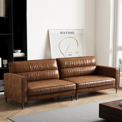Canapé trois places de style moderne du milieu du siècle, en similicuir brillant, avec assises profondes et dossier capitonné, idéal pour le salon ou un appartement.