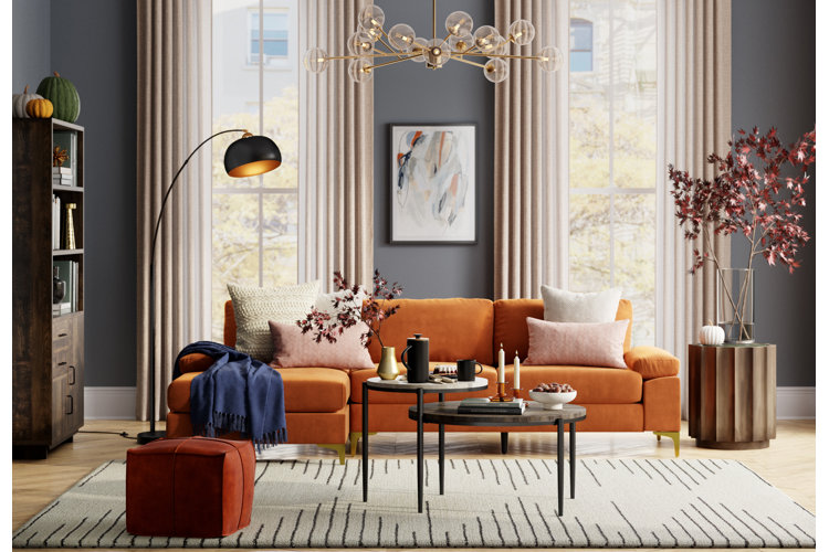 Living room with medium-gray walls, an orange sofa, and a sputnik chandelier.